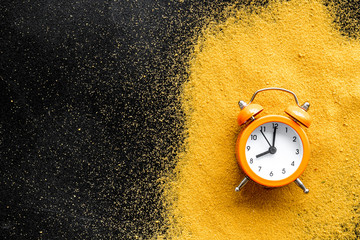 Deadline concept. Clock on sand on black background top-down copy space