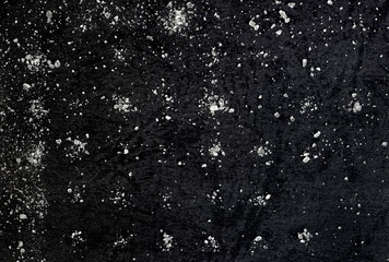 Obraz premium Salt on a background of black texture paper turned out to be a matrix in the manufacture of cookies. Abstraction of the starry sky.