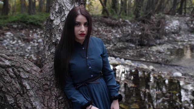 Portrait of a beautiful gothic woman posing in the forest.