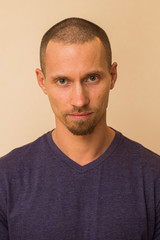 Obraz premium Portrait of a brooding young man in a blue or purple photoball against a beige wall