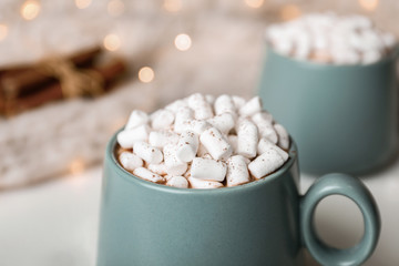 Obraz na płótnie Canvas Delicious cocoa drink with marshmallows on table against blurred lights, closeup