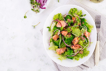 Salad of baked fish salmon, broccoli, lettuce, red onion and dressing. Fish menu. Seafood - salmon. Top view, overhead