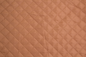 Quilted fabric. The texture of the blanket.	Beige textile