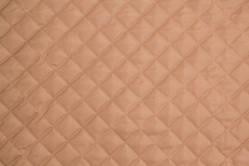 Fototapeta premium Quilted fabric. The texture of the blanket. Beige textile