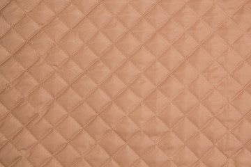 Quilted fabric. The texture of the blanket.	Beige textile