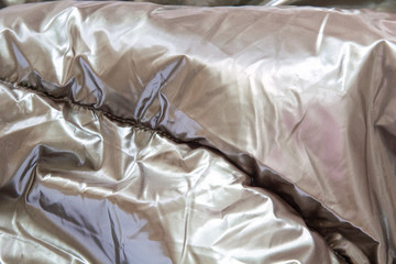 Silver shiny metal creased background. Glitter grey color, thin sheet foil texture with dented...