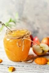 Homemade apple jam with orange zest. Jam in a glass jar. Jam on a wooden background, top view. Place for text