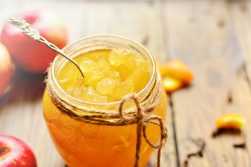 Homemade apple jam with orange zest. Jam in a glass jar. Jam on a wooden background, top view. Place for text