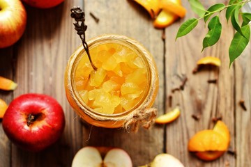 Homemade apple jam with orange zest. Jam in a glass jar. Jam on a wooden background, top view. Place for text
