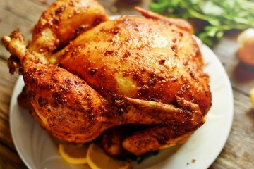 Whole baked chicken curry with golden crisp. Baked chicken on a wooden background.