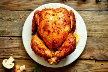 Whole baked chicken curry with golden crisp. Baked chicken on a wooden background.