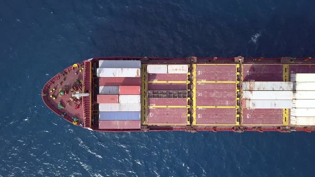 Large container ship  prow, loaded with various container brands. Aerial top down shot of cargo ship loaded with containers.
