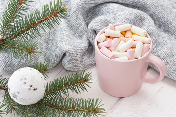 Obraz na płótnie Canvas Hot cocoa with marshmallows in a pink mug on a white wooden background (table).