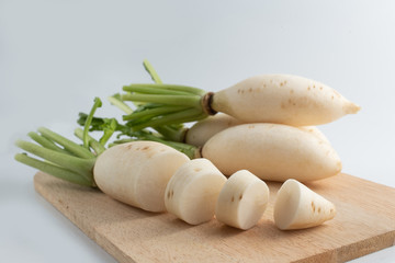 White radish on a wooden cutting board, white background