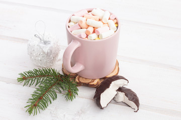 Hot chocolate with marshmallows in a pink cup on a white wooden background (table).