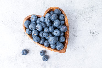 healthy eating antioxidant blueberries in a wooden bowl heart shaped top view - 308897004