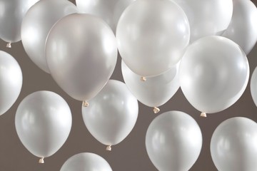 white balloons flying on beige background