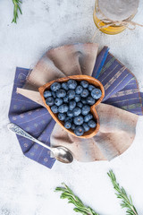 blueberries in a wooden plate in the shape of a heart
