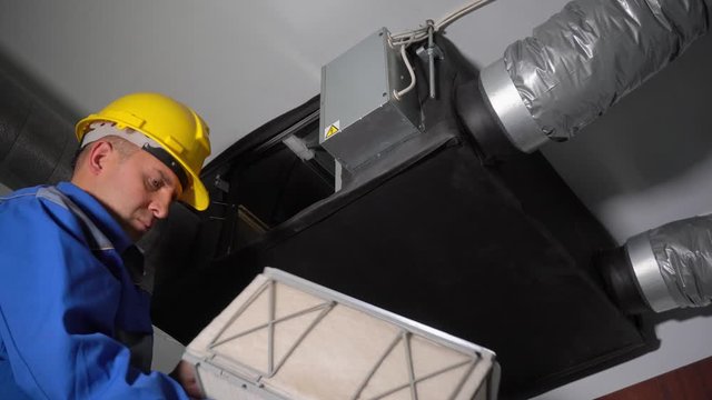 Professional specialist changing air ventilation system filters