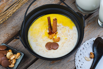 Traditional breakfast. Milk oatmeal with chocolate and granola. on a wooden table.