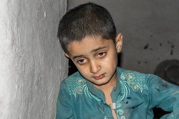 a child wearing dirty clothes and sitting on the ground and feeling so lonely and depressed 