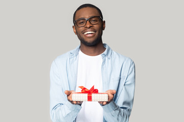 Cheerful african american millennial guy holding present box head shot portrait.