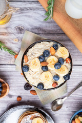 rustic delicious Breakfast oatmeal with nuts and bananas and pancakes