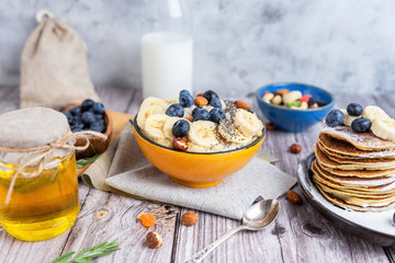 rustic Breakfast pancakes on a plate with blueberries and oatmeal - 308900266