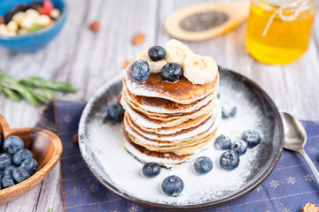 delicious Breakfast pancakes on a plate with blueberries and honey