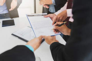 Businessman offering contract paper to his business partner for sign contract.