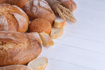 Freshly Baked Homemade Bread, close-up, isolated on a white background. Assortment of baked bread on wooden table background