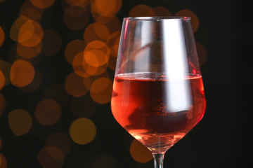 Glass of tasty wine on dark background