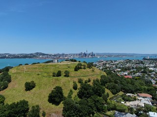 Devonport, Auckland / New Zealand - December 11, 2019: The Victorian Style Seaside Village of Devonport, with the skyline of Auckland’s landmarks and CBD in the background