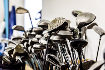 Golf caddy room storage room with sets of poles irons.