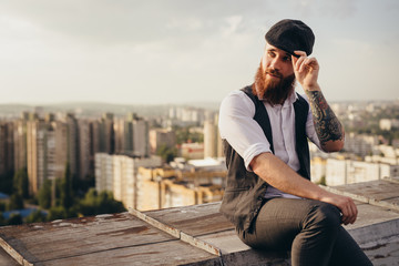 Stylish hipster resting on rooftop