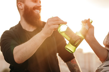 Crop couple drinking beer during date