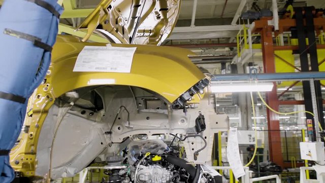 Car engine assembly on the production line inside an automobile manufacturing plant