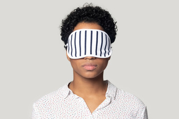 Young african american woman standing with sleeping mask on eyes.