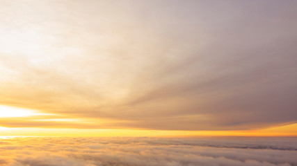 Fototapeta premium Aerial view White clouds in blue sky. Top view. View from drone. Aerial bird's eye view. Aerial top view cloudscape. Texture of clouds. View from above. Sunrise or sunset over clouds