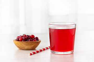 Glass with fresh organic cranberry juice and red cranberries.