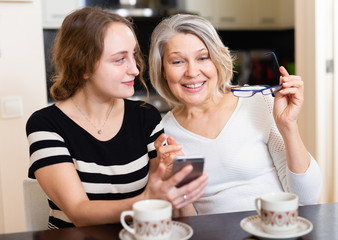 Mother with daughter using smartphone