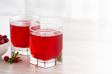 Glass with fresh organic cranberry juice and red cranberries.