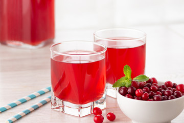Glass with fresh organic cranberry juice and red cranberries.