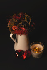 Centro floral rústico navideño en jarra esmaltada con vela y adornos