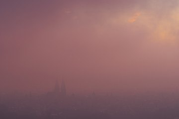 Scenic overview of the old town of Regensburg in dense morning fog during winter