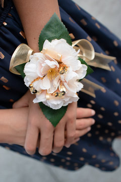 Closeup of a floral corsage on the arm of a high school girl attending her graduation