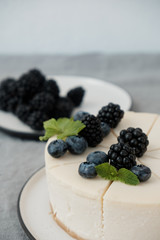 Homemade cheesecake with fresh berries. a piece of cheesecake with a blackberry in the foreground