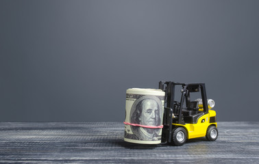 Forklift truck carries a dollars money roll. Making money and increasing capital accumulation....