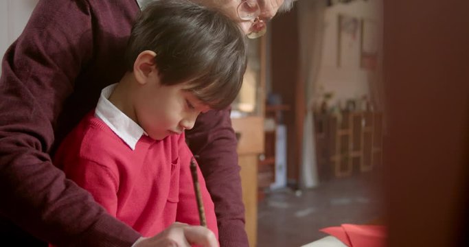 Grandfather and grandson writing calligraphy on couplets,4K