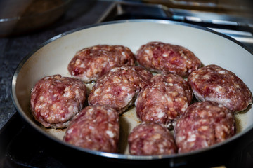 Chops. Fried cutlets in a cast iron pan on the stove. The process of cooking cutlets in the kitchen.